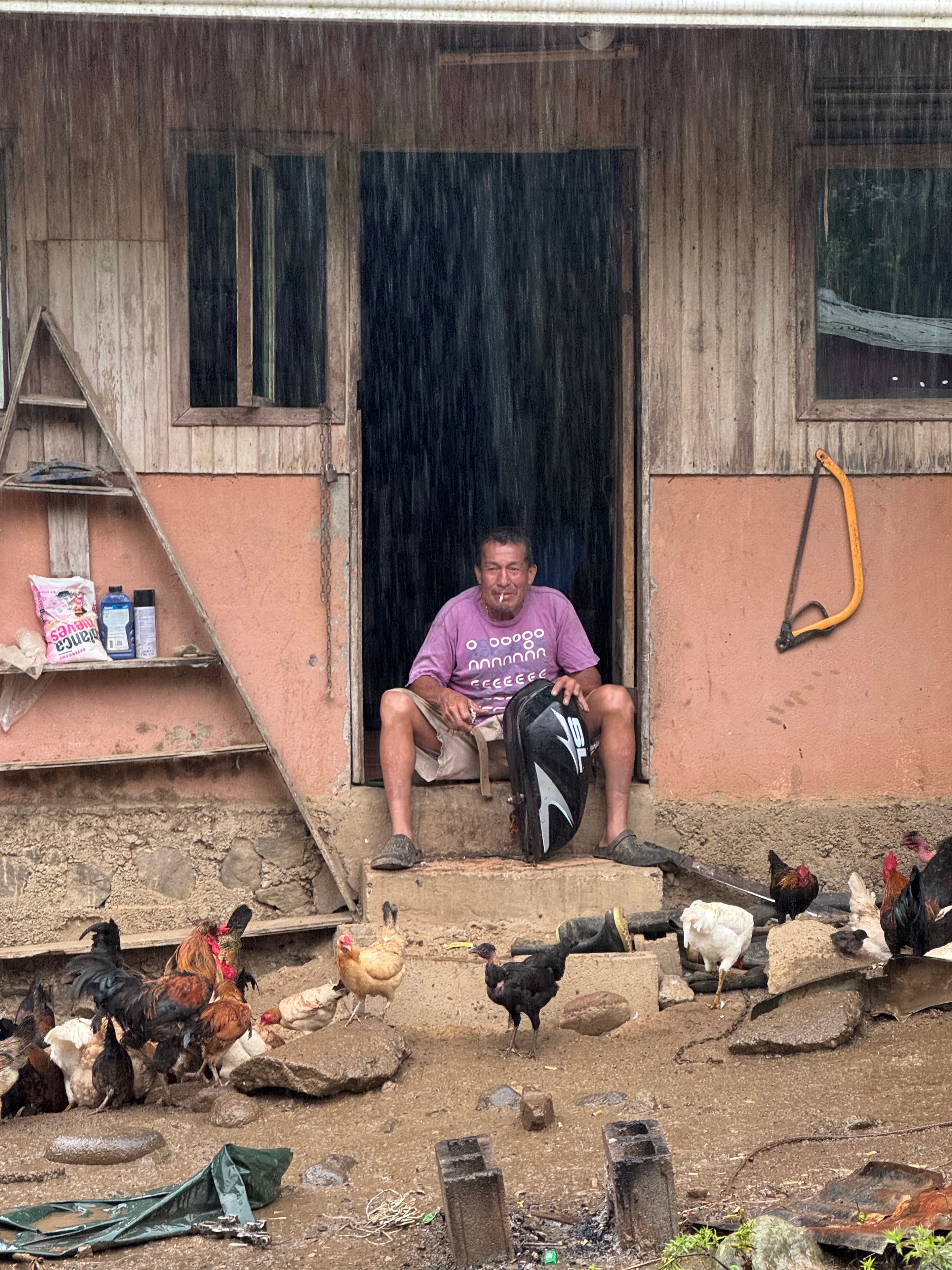 Costa Rica trek — local man in doorway during heavy rain